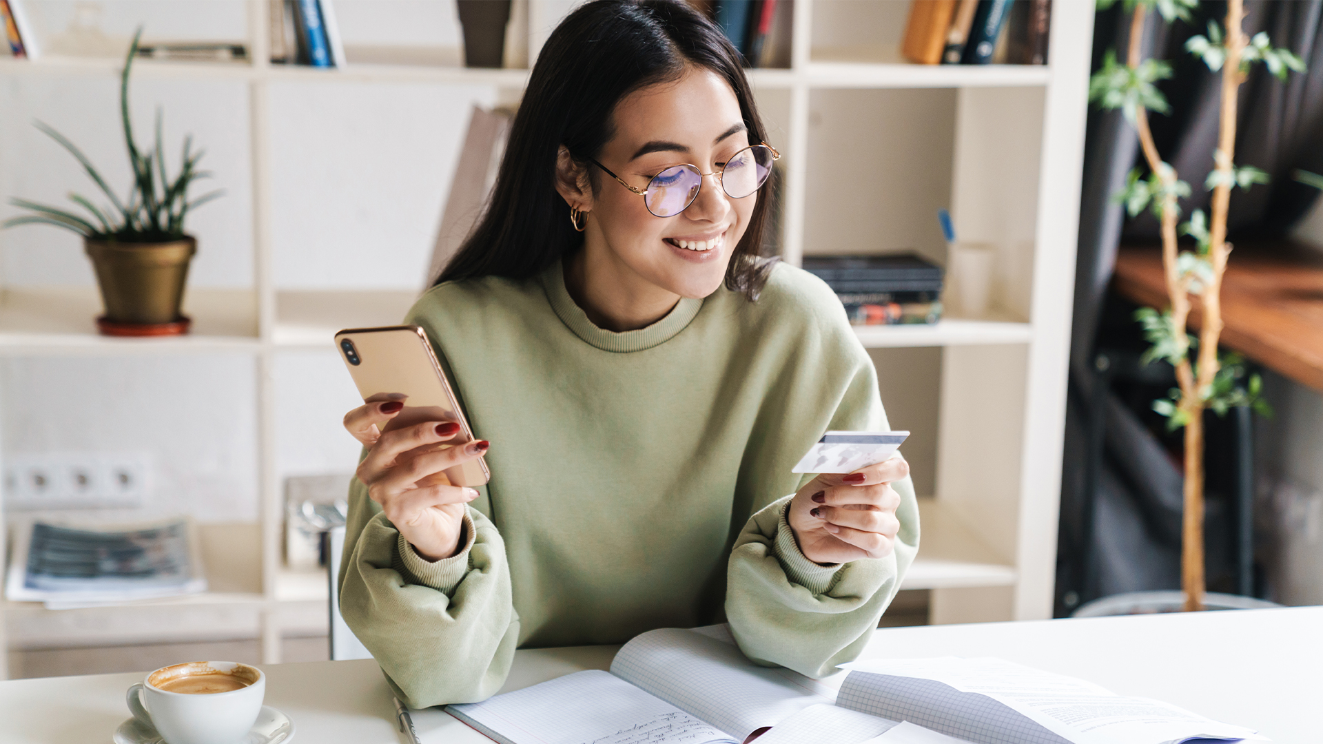 Happy optimistic young girl student holding credit card.