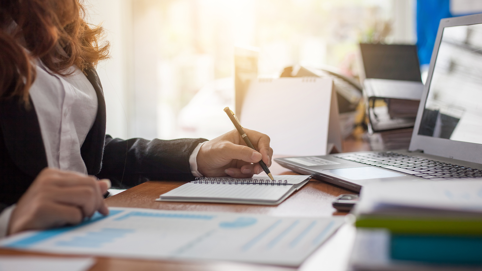 Business woman at working with financial reports and laptop computer in the office