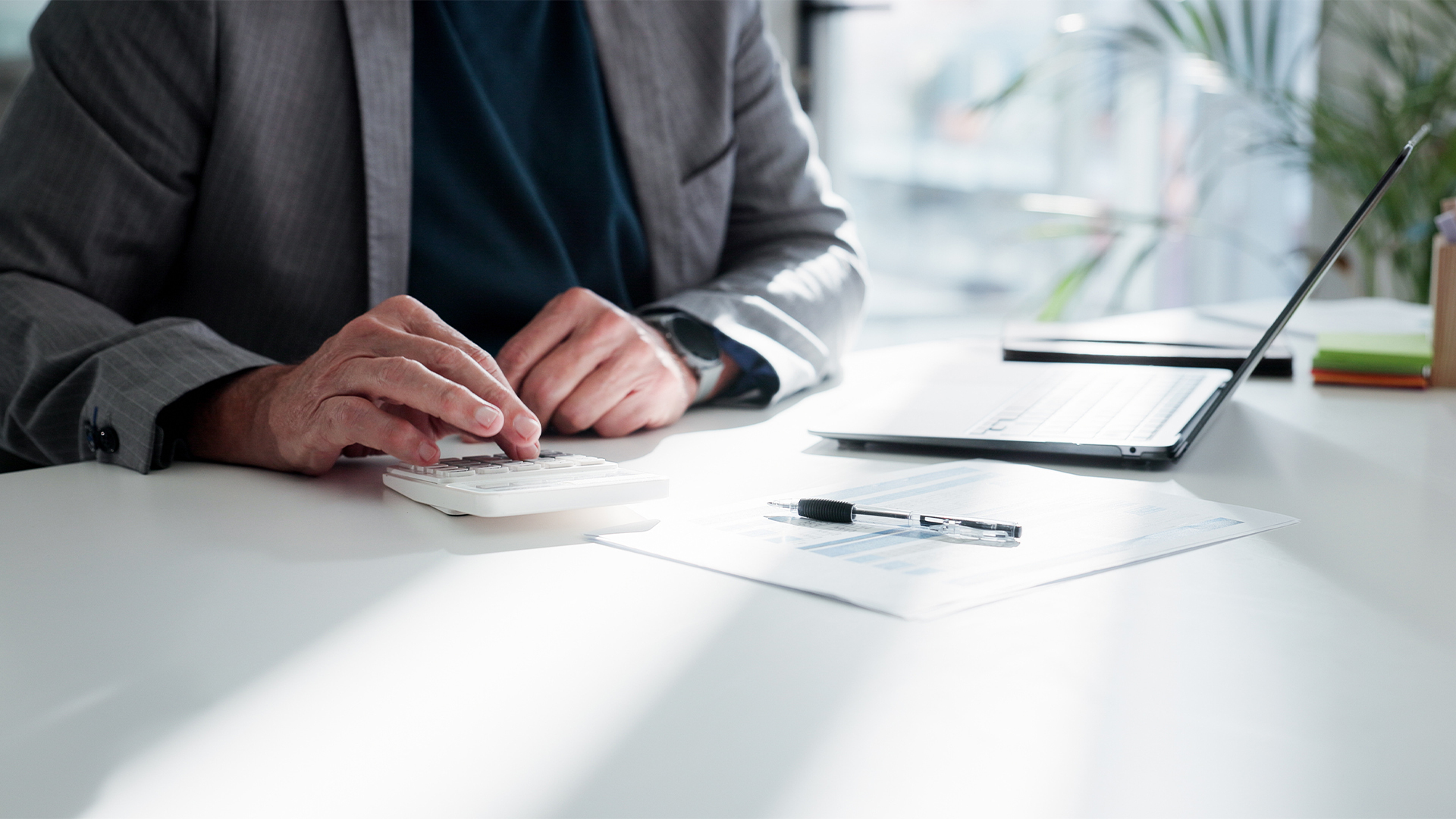 Businessman, hands or finance with calculator or documents for project budget or expenses in office.