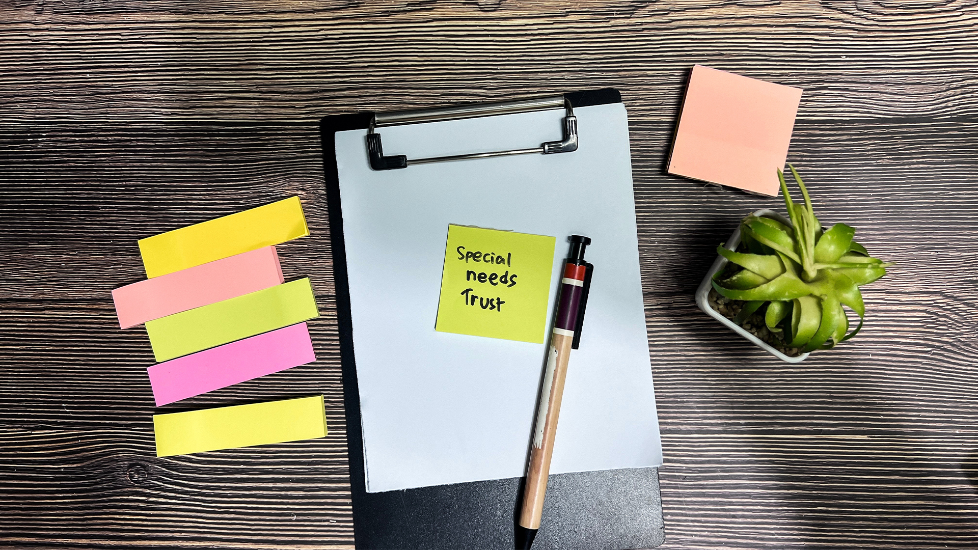Concept of Special Needs Trust write on sticky notes isolated on Wooden Table.
